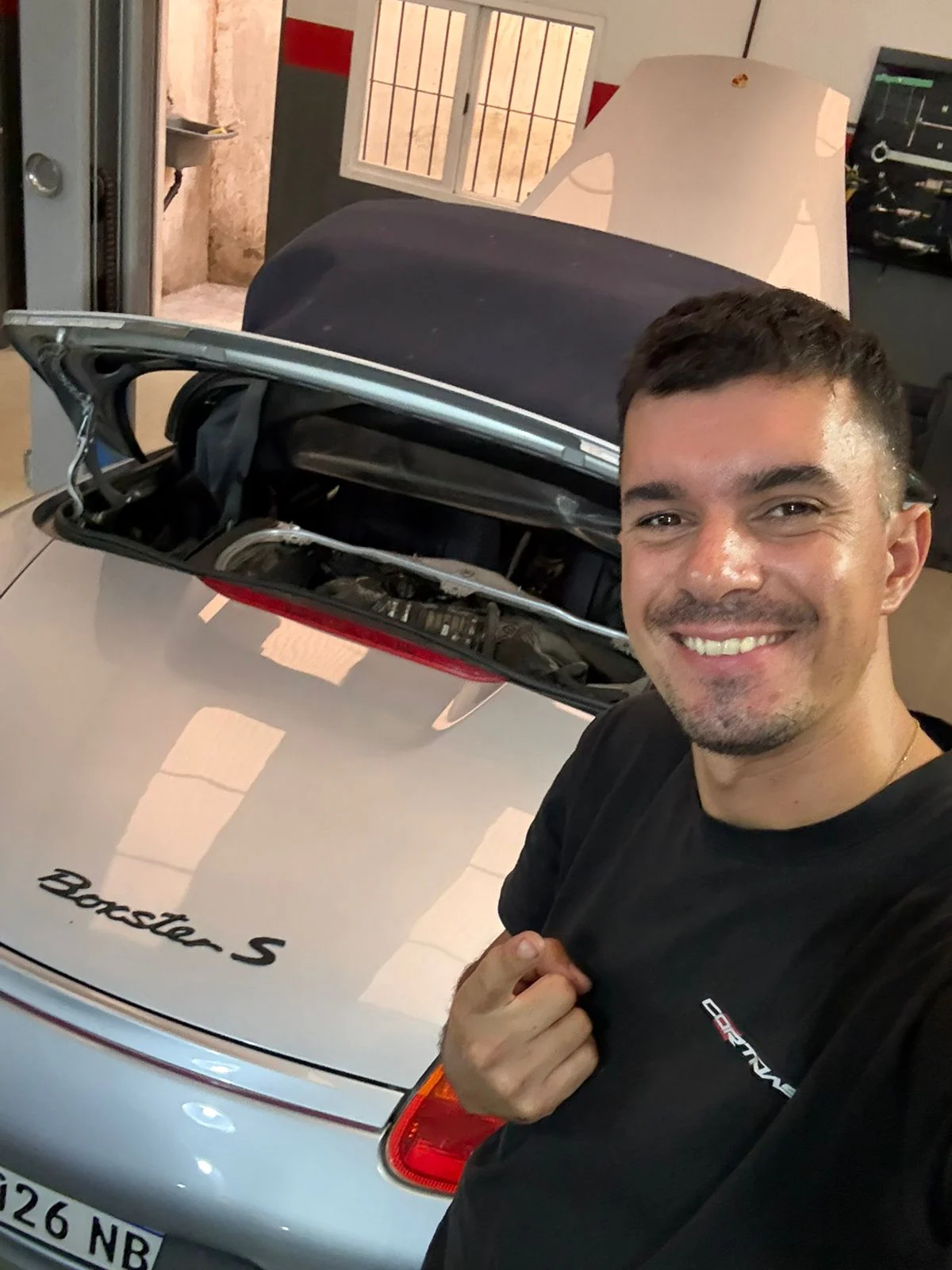 Rodrigo Cortiñas junto a un Porsche Boxster en el taller